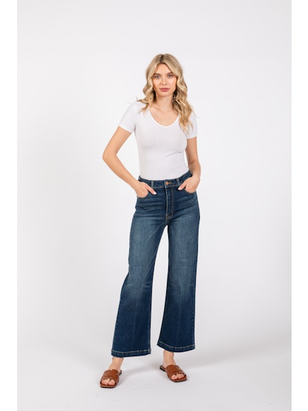 Woman wearing a white t-shirt and blue jeans on a white background
