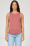 Woman wearing a pink sleeveless top and light blue jeans on a white background